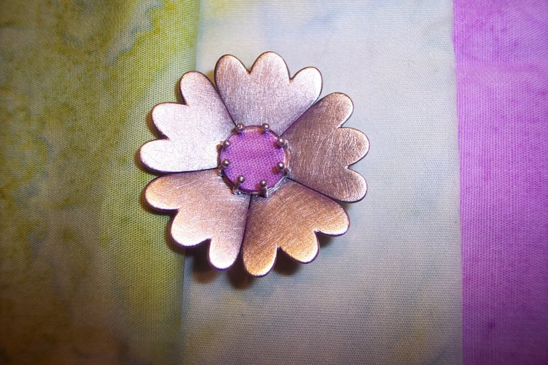 A brooch Annie made for her mother based on her mother’s quilt “Gloria’s Garden”.